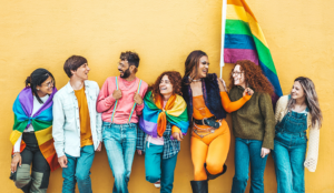 Multicultural Gen Z LGBTQ+ adults with a pride flag