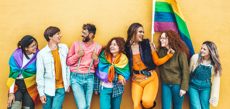 Multicultural Gen Z LGBTQ+ adults with a pride flag