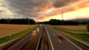 An empty road at sunset with trees and fields in the distance