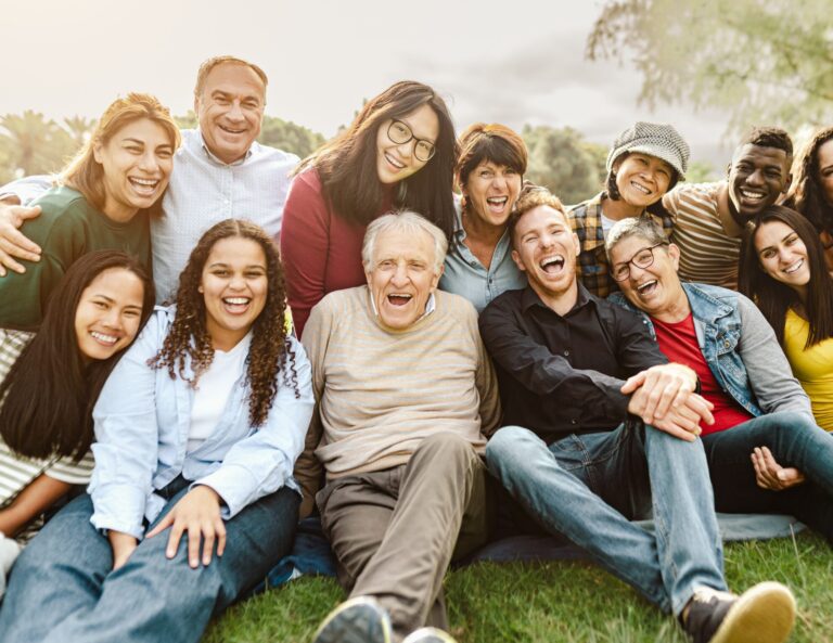 Multigenerational, multicultural group of people sitting together, posing for a photo