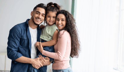 Young Hispanic couple embracing their young daughter