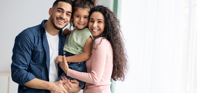 Young Hispanic couple embracing their young daughter