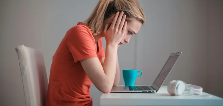 Distraught woman looking at her laptop