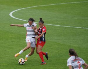 women on playing a game on a soccer field