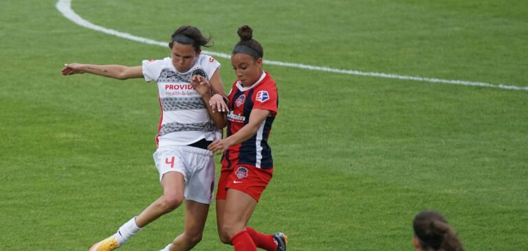 women on playing a game on a soccer field