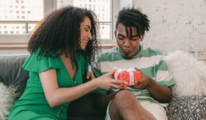 Gen Z black couple giving gifts to each other