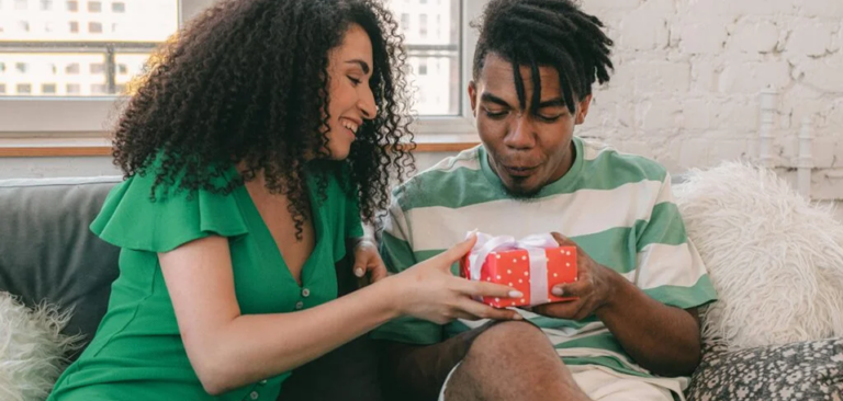 Gen Z black couple giving gifts to each other
